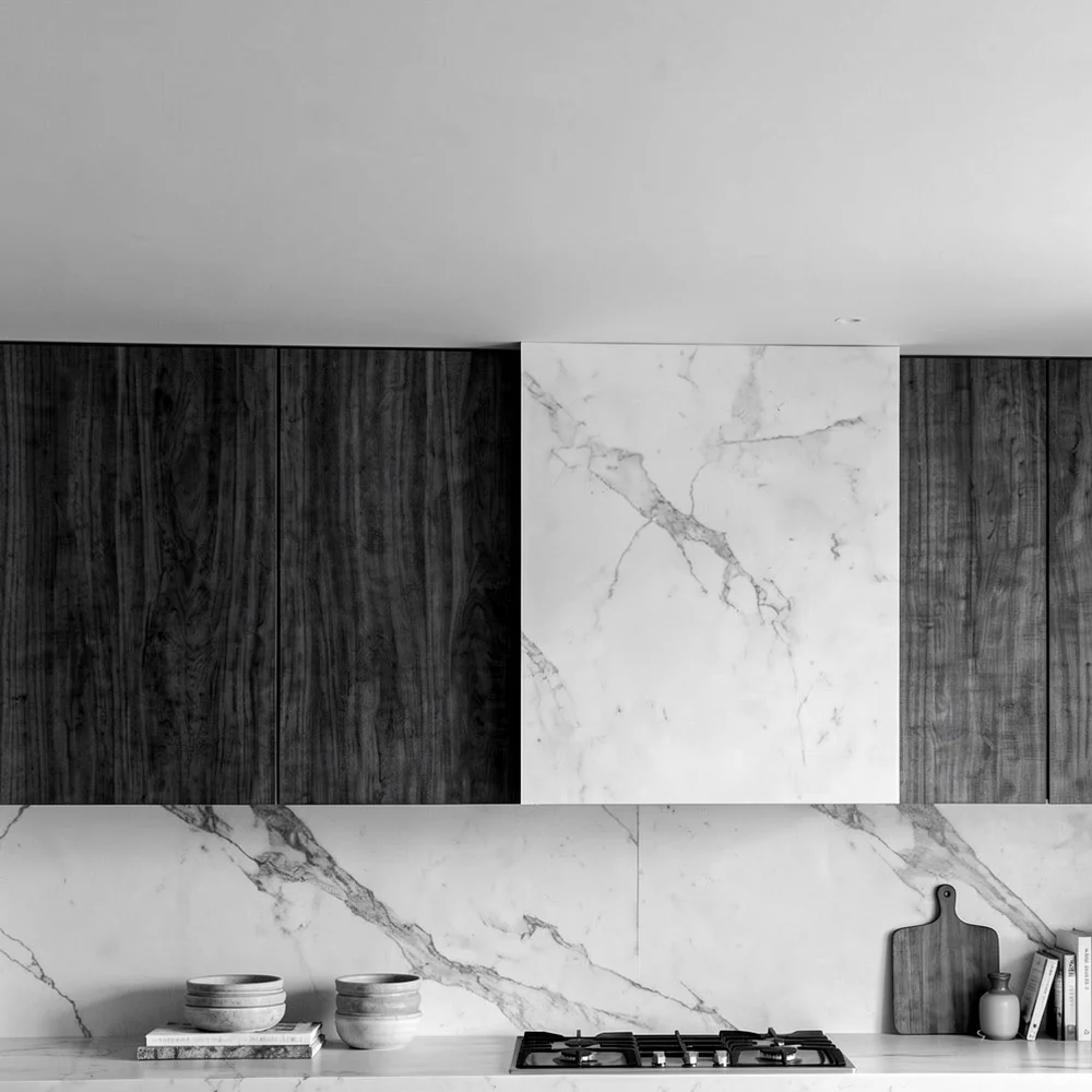 Detail: the marble hood between the walnut cabinets, in black and white